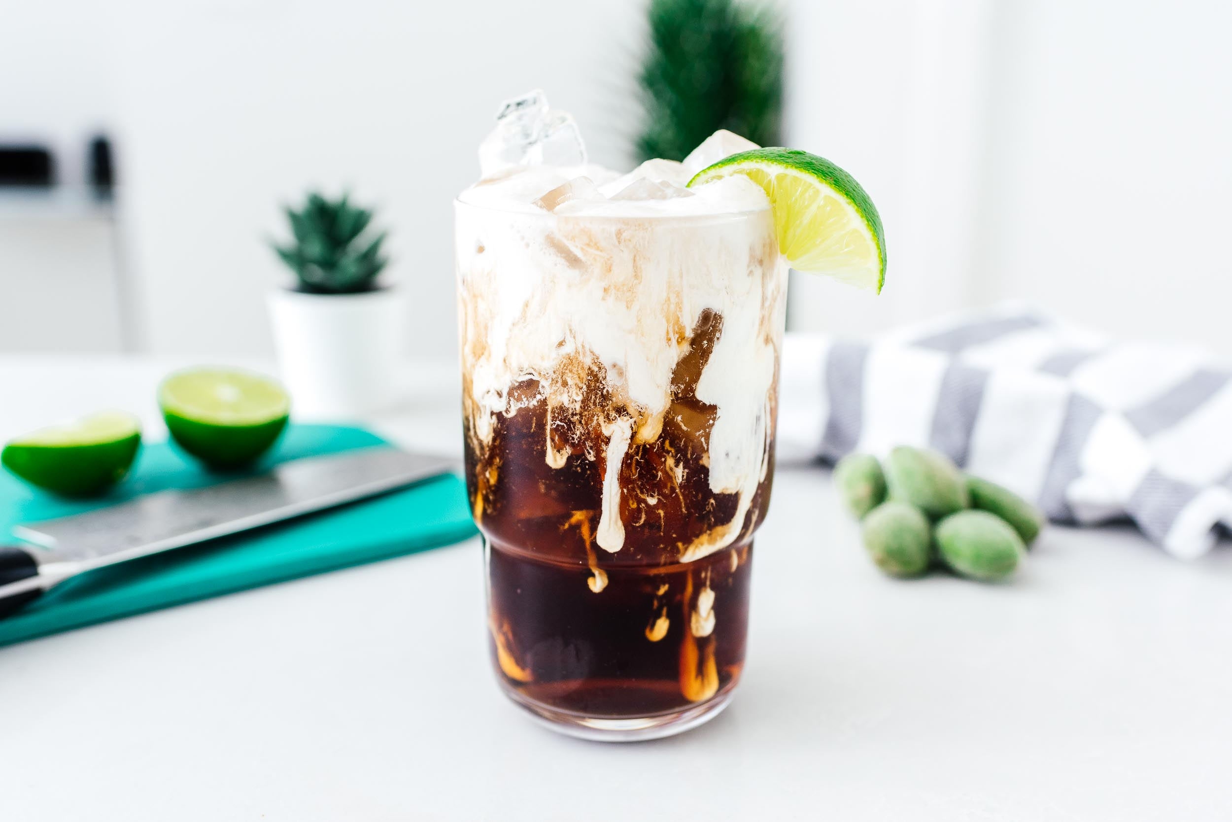 Dark soda poured over ice with a wedge of lime