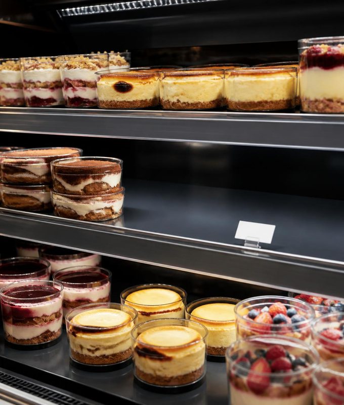 Chilled dessert pots on retail shelves with one shelf empty